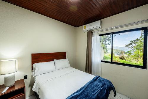 a bedroom with a bed and a window at Arenal Summit in Nuevo Arenal