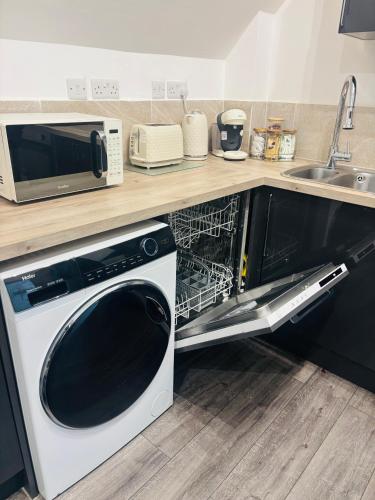 a microwave and a dishwasher in a kitchen at The Luxe Haven Penthouse - Sleeps 4 Apartment Nottingham City Centre in Nottingham