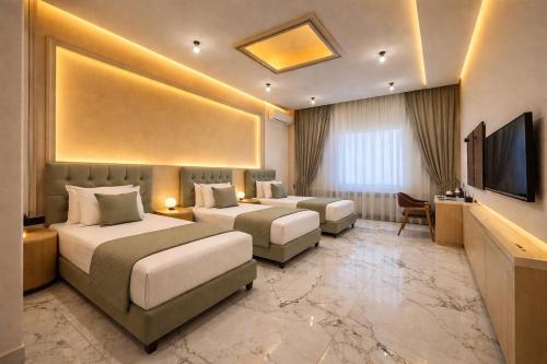 een hotelkamer met twee bedden en een televisie bij Khatai Aura Hotel in Baku