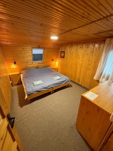a bedroom with a bed in a wooden cabin at Cabana Rânca in Ranca