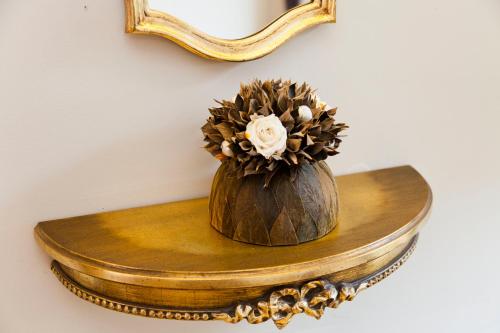 a vase with a flower sitting on a table under a mirror at Hotel Diamonds and Pearls in Antwerp