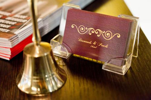 a wooden table with a diplomatic card and a shaker at Hotel Diamonds and Pearls in Antwerp