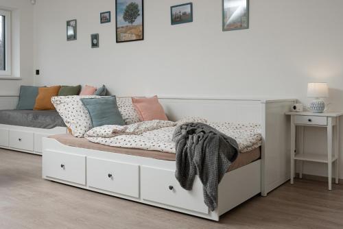 a bedroom with a white bed with pillows at Horský sen - Mountain Dream Apartment B1 in Špičák