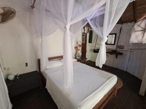 a bedroom with a white bed with a canopy at Maloka Napü - Ecodestinos in Puerto Nariño