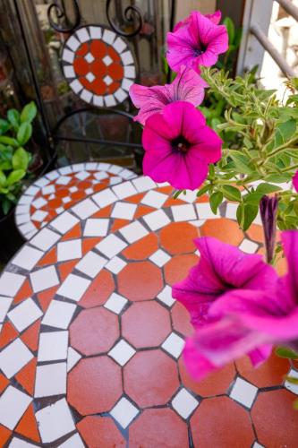 a table with pink flowers on a tiled floor at Hotel Diamonds and Pearls in Antwerp