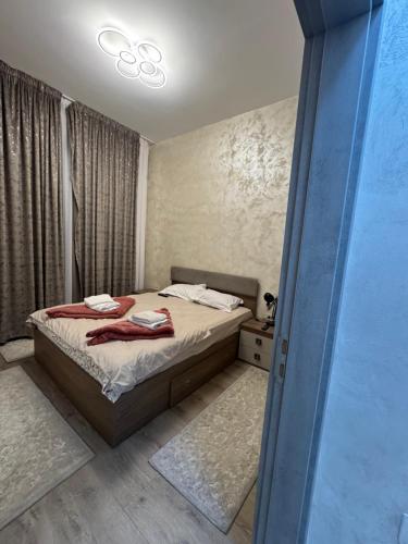 una camera da letto con un letto con asciugamani sopra di Dady's Apartament a Roşu