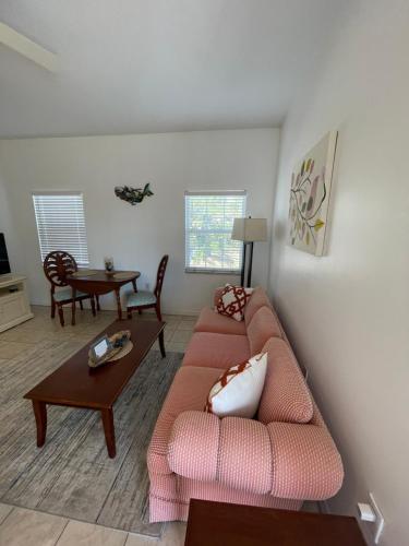 a living room with a pink couch and a table at Sarasota -Walk to Siesta Key Beach in Sarasota