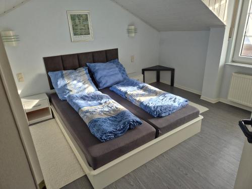 un letto con cuscini blu sopra di Gemütliches Gästehaus in ruhiger Waldlage a Büdingen