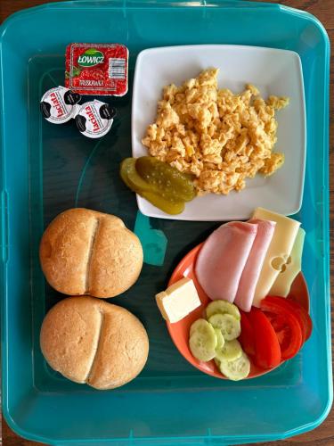 una scatola per il pranzo con un vassoio di cibo con hot dog e verdure di Główna Apartamenty Nad Nogatem a Malbork