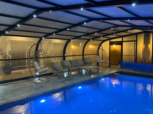 a large swimming pool with chairs and a swimming pool at Country breeze park in Majdal Shams