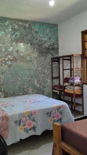 a bedroom with a painting on the wall at Sol&Mar Paraty Mirim in Paraty