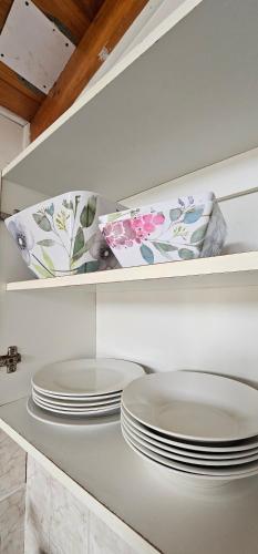 a kitchen with white plates on a white shelf at Cabaña El Quisco 2do piso con estacionamiento in El Quisco