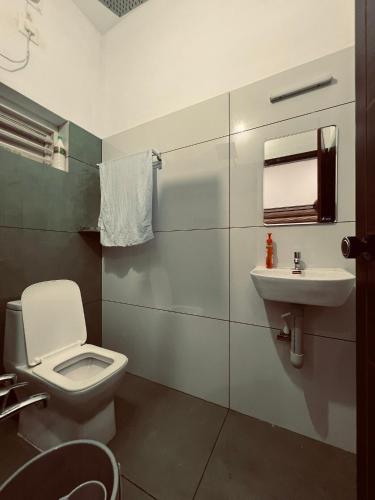 a bathroom with a toilet and a sink at Green Villa Chirackal Gardens in Trichūr