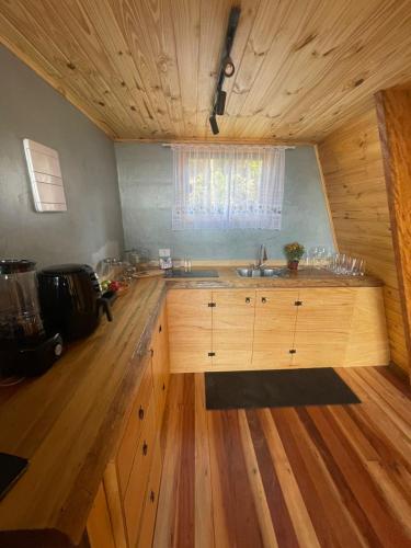 a kitchen with wooden cabinets and a wooden floor at Chalé Colinas in Campos do Jordão