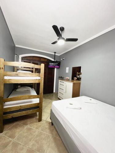 a bedroom with two bunk beds and a ceiling fan at Hostel Anprado #3 Kit café incluso, Próx-Aeroporto de Guarulhos in Guarulhos