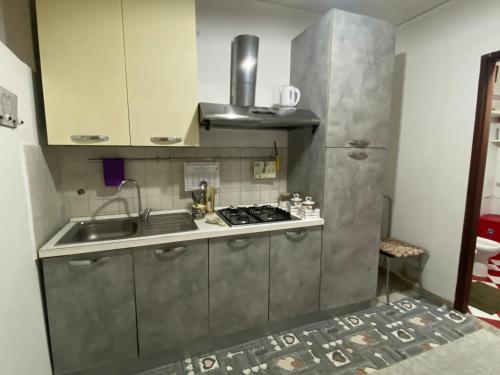 a kitchen with a sink and a stove at Casa vacanza La Ninfea intera casa in Caltagirone