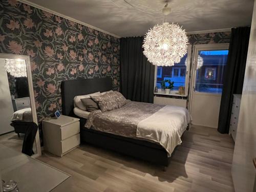 a bedroom with a bed and a chandelier at Rymligt radhus in Borlänge