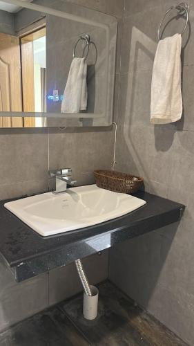 a bathroom with a white sink and a mirror at Seven sky hotel in Murree