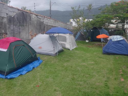 un gruppo di tende che si trovano nell'erba di Acampamento Aloha Solemar a Praia Grande