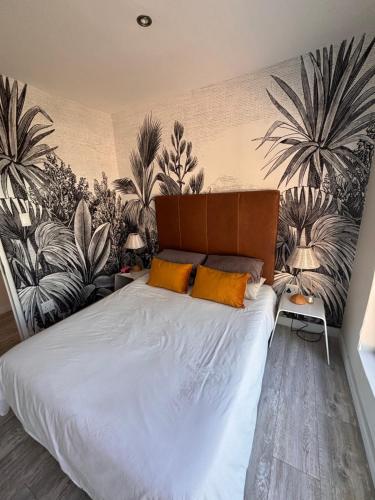 een slaapkamer met een groot bed met planten aan de muur bij Beach House in Pearly Beach