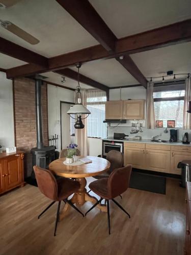 a kitchen with a table and chairs in a room at Huisje Buurserbeek in Haaksbergen