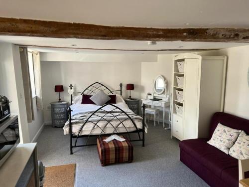 a bedroom with a bed and a desk and a chair at Pitfield Apartments in Willand