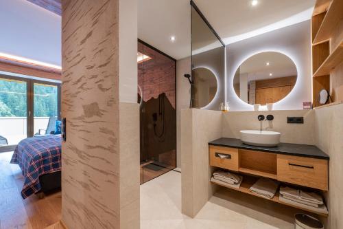 un bagno con lavandino e specchio di Boutiquehotel Grandau a Sankt Gallenkirch