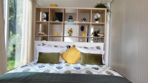 a bedroom with a bed with pillows and a window at Personal blue house Madeira in Santa Cruz
