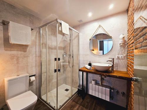 een badkamer met een glazen douche en een wastafel bij Apartamentos Estela de Altamira in Santillana del Mar