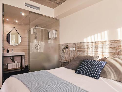 een slaapkamer met een bed, een douche en een wastafel bij Apartamentos Estela de Altamira in Santillana del Mar