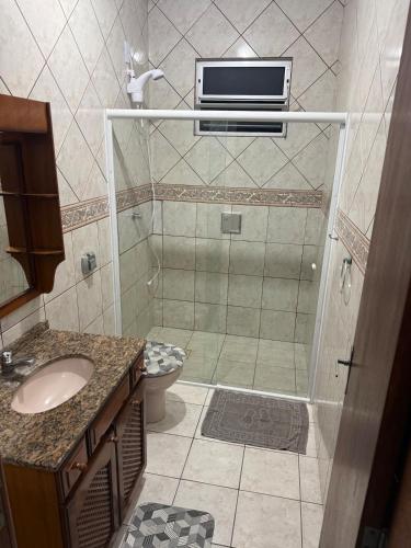 a bathroom with a shower and a toilet and a sink at Casa Premium com Jacuzzi e Churrasqueira in Palhoça