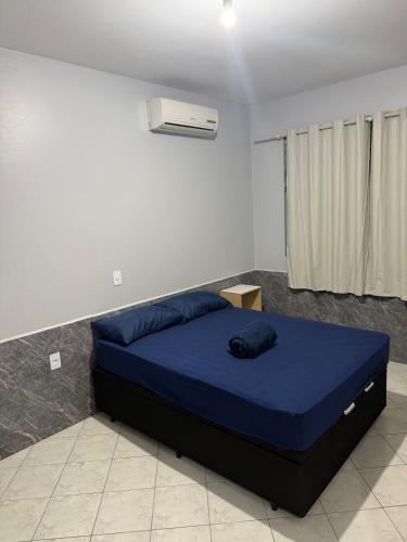 a bedroom with a blue bed in a room at Casa Premium com Jacuzzi e Churrasqueira in Palhoça