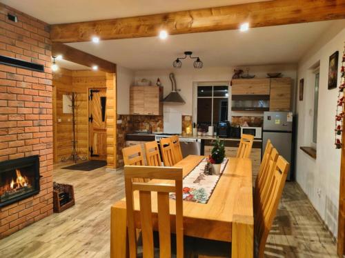 una cucina con tavolo in legno e camino di Chata nad Roztokami a Baligród
