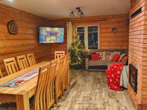 un soggiorno con albero di Natale, tavolo e sedie di Chata nad Roztokami a Baligród