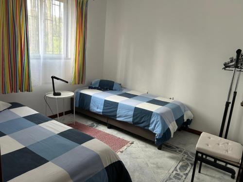 a bedroom with two beds and a table and a window at Quinta do Marnoto in Gafanha do Carmo