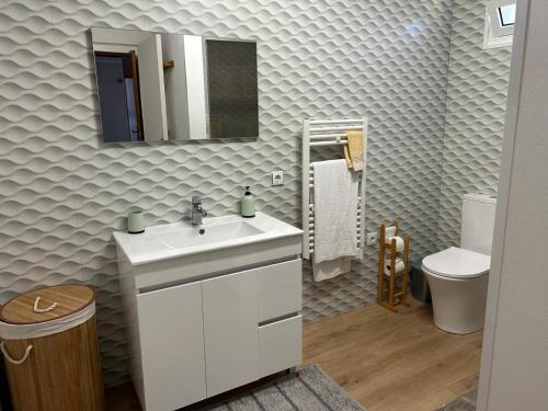 a bathroom with a sink and a mirror and a toilet at Quinta do Marnoto in Gafanha do Carmo