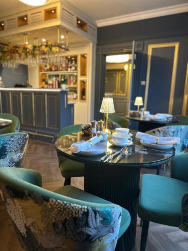 een restaurant met een tafel en stoelen, borden en schalen. bij No.4 Carlton in Southampton