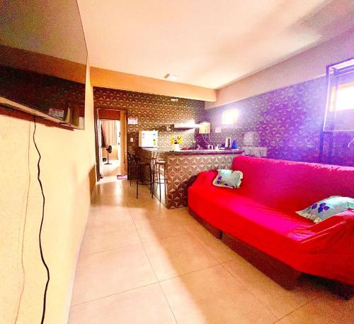 un divano rosso in un soggiorno con cucina di Apto 112 CENTRO a Araguaína