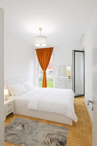 biała sypialnia z dużym łóżkiem i oknem w obiekcie Peja Central Hideaway w mieście Peć