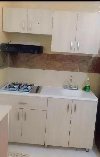 a white kitchen with a stove and a sink at Right Lang Deh Soh in San Andrés