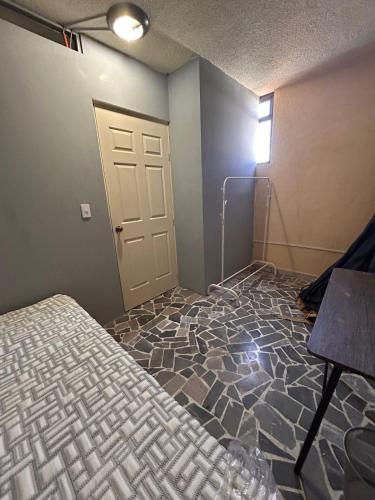 an empty room with a bed and a door at Departamentos Apizaco Jardin de Toribio in Apizaco