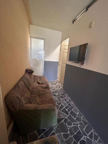 a room with a bed and a flat screen tv at Departamentos Apizaco Jardin de Toribio in Apizaco
