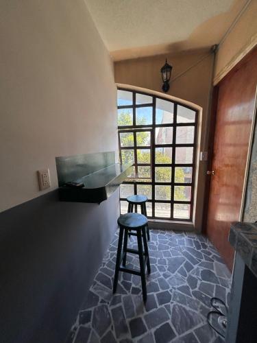 a stool sitting in a room with a window at Departamentos Apizaco Jardin de Toribio in Apizaco