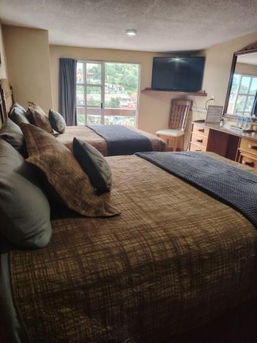 a bedroom with two beds with pillows and a television at Casa Real Cortés in Mineral del Monte