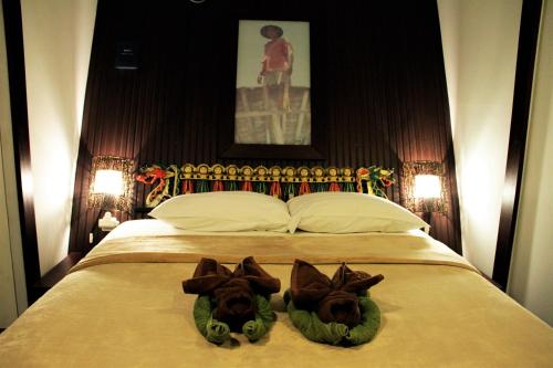 a bedroom with a bed with two towels on it at Bali Umah Tinjung in Tulamben