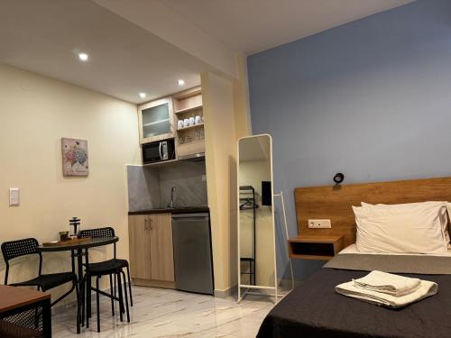 新马尔马拉斯Agapaki Studios的一间带床、桌子的卧室和一间厨房