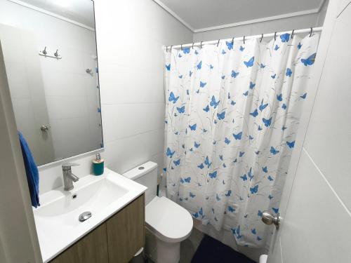 a bathroom with a toilet and a shower curtain at Nuevo departamento cercano a playa y comercio in Viña del Mar