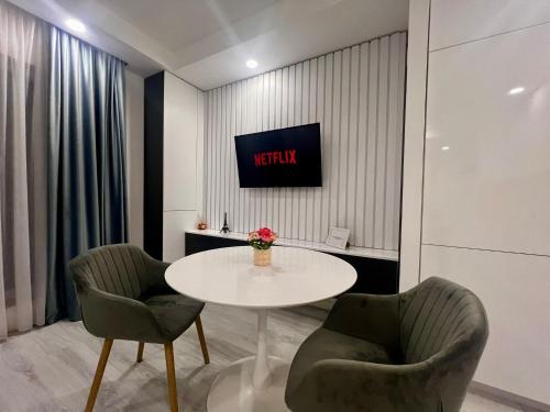 a room with a table and two chairs and a tv at Nivora apartament #freeparking in Tunari
