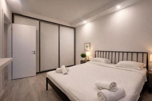 a bedroom with a large white bed with towels on it at Nivora apartament #freeparking in Tunari