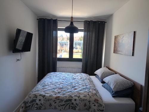 a bedroom with a bed and a window at A-Apartman in Bjelašnica